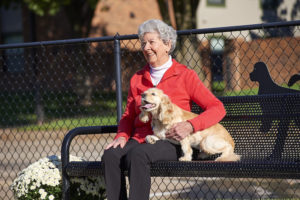 A senior woman enjoys a day outside with her dog