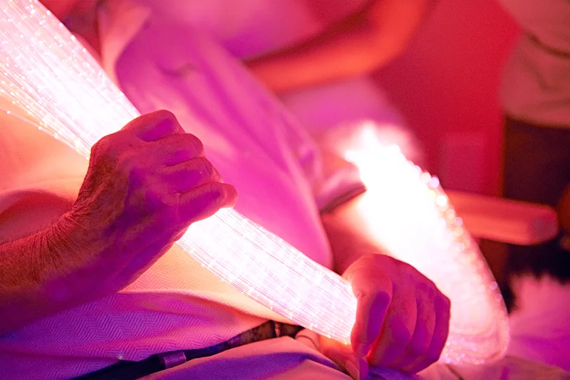 a woman holding a lighted tube in the memory care unit