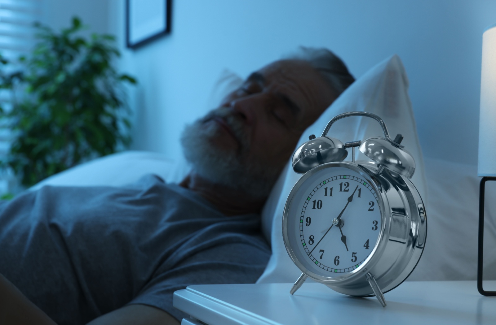 A content senior sleeps in their bed at a senior living community.